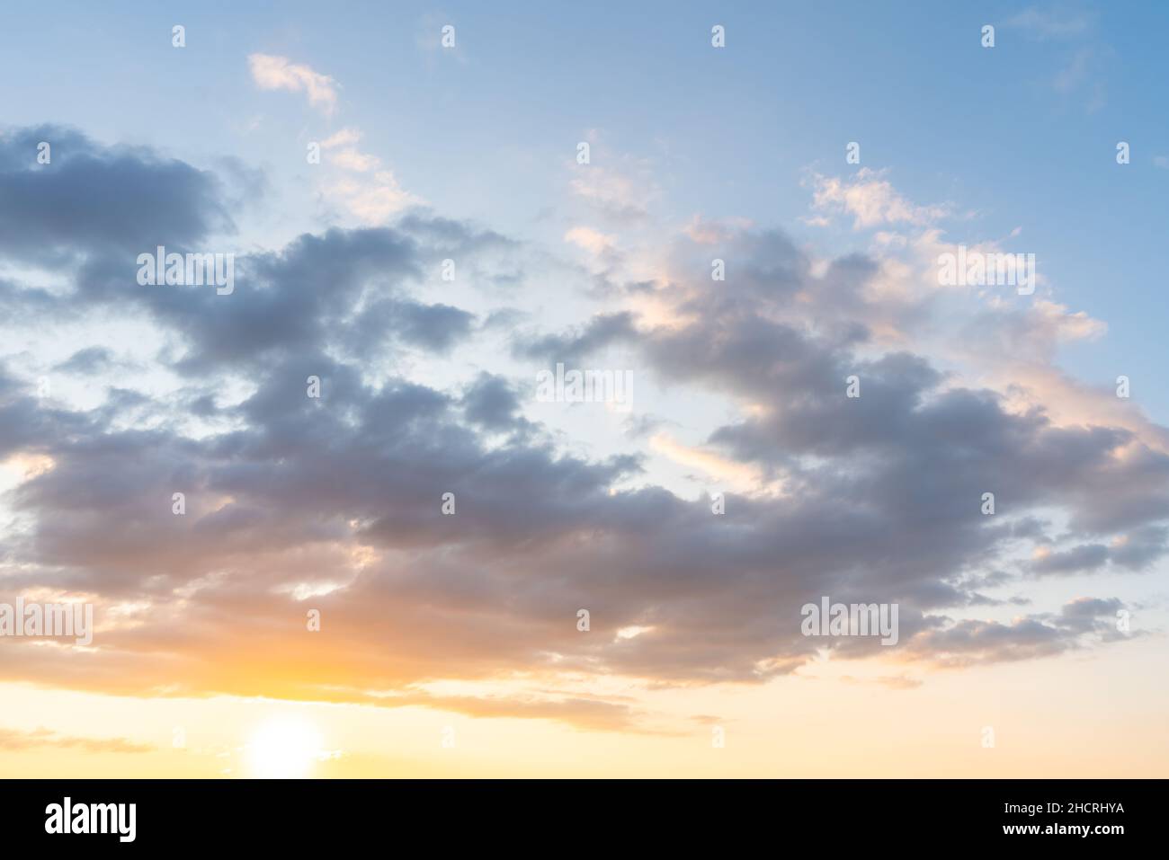 sunset clouds with sun setting down Stock Photo
