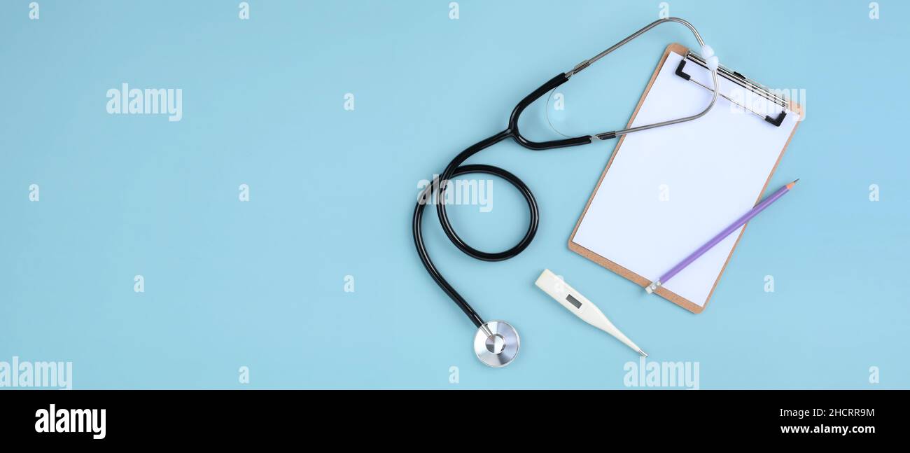 Top view of doctor desk table with stethoscope, blank paper on ...