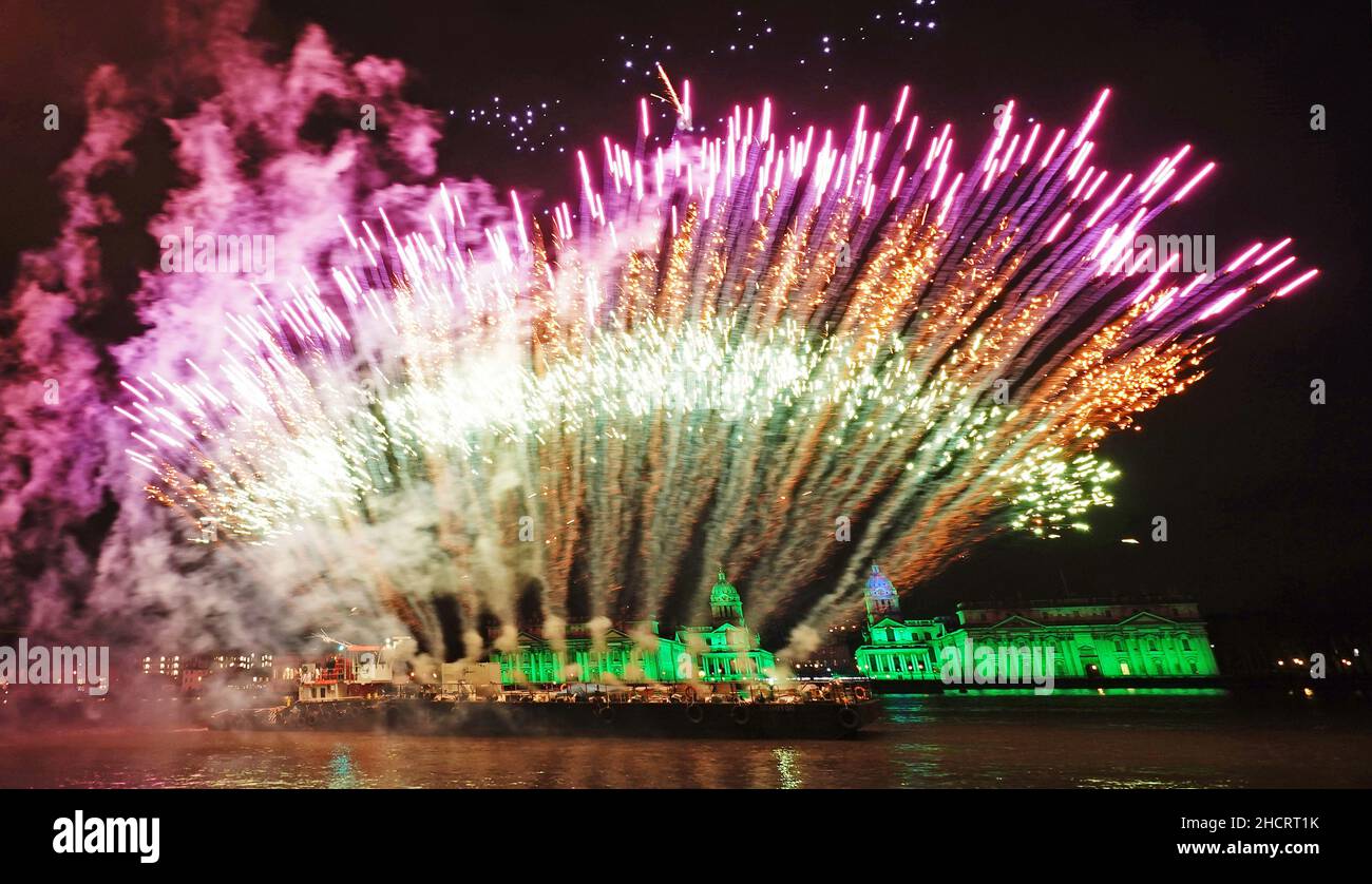 Drones and fireworks illuminate the night sky over the Old Royal Naval College in London after the capital's normal New Year's Eve fireworks display was cancelled due to the coronavirus pandemic. Picture date: Saturday January 1, 2022. Stock Photo