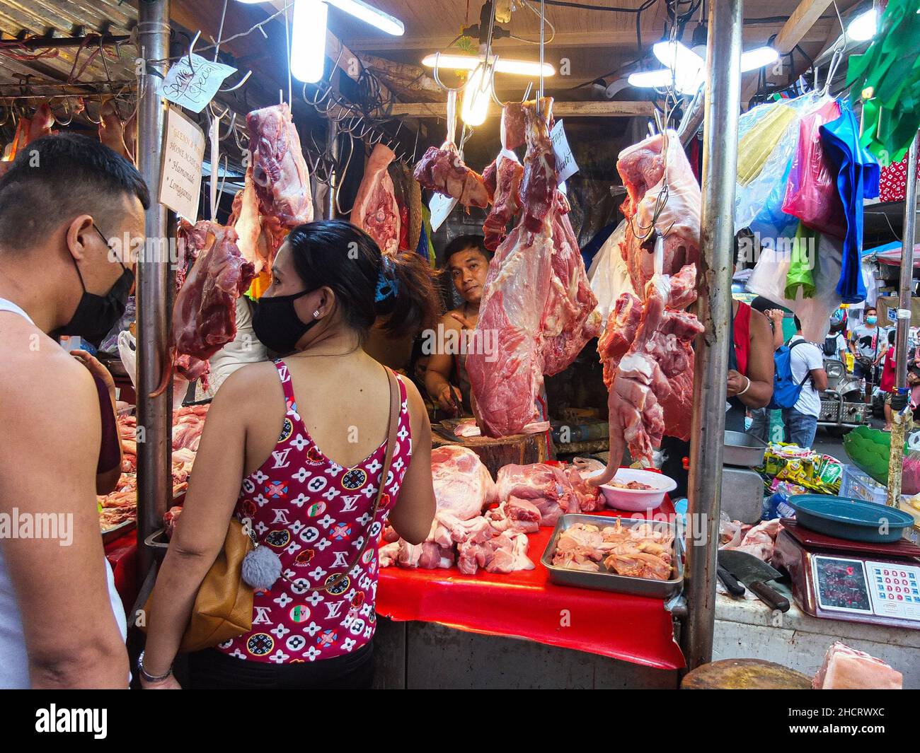 Manila, Philippines. 31st Dec, 2021. A couple choosing what to buy at the pork stall ahead of New Year's Eve in Divisoria. Credit: SOPA Images Limited/Alamy Live News Stock Photo