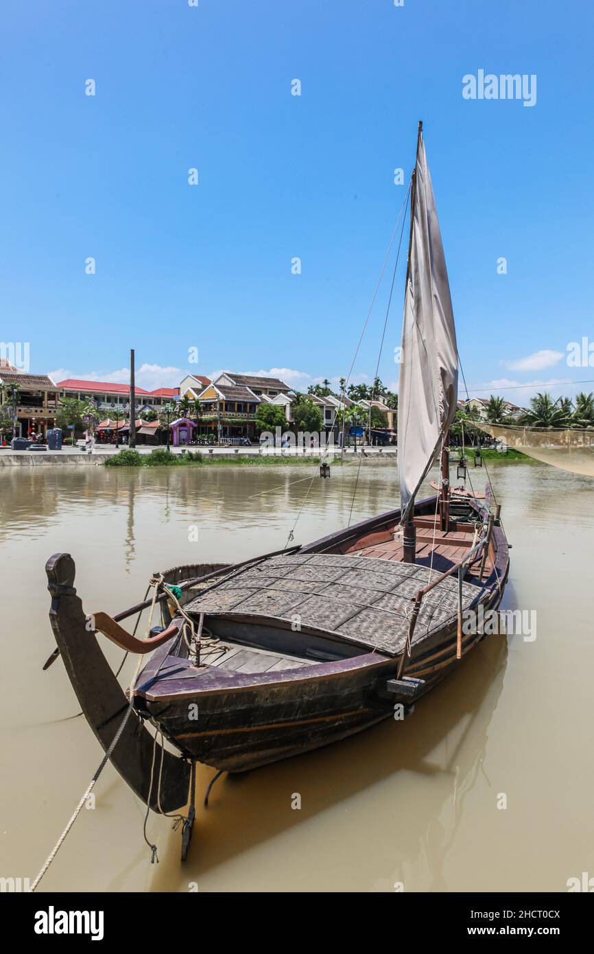 A traditional sailing boat in the Thu Bon River at Hoi An Vietnam. Hoi An is an historic trading port which is an amazing tourist destination. Stock Photo