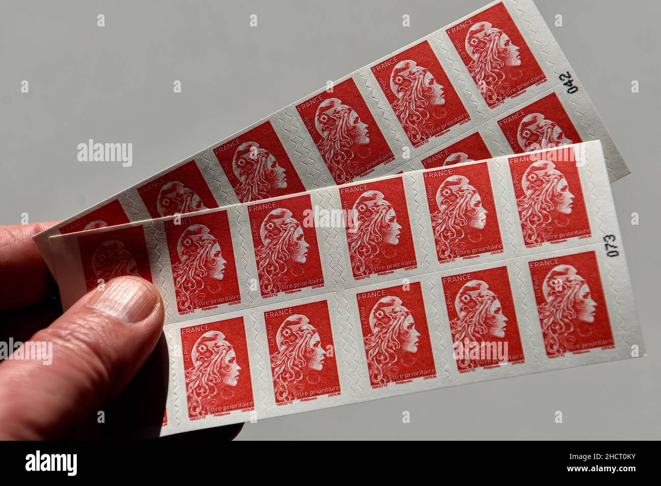 In this photo illustration, a hand seen holding post stamps. The La