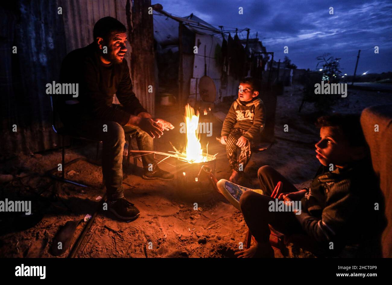 Gaza, Palestine. 31st Dec, 2021. A Palestinian family sits around fire ...