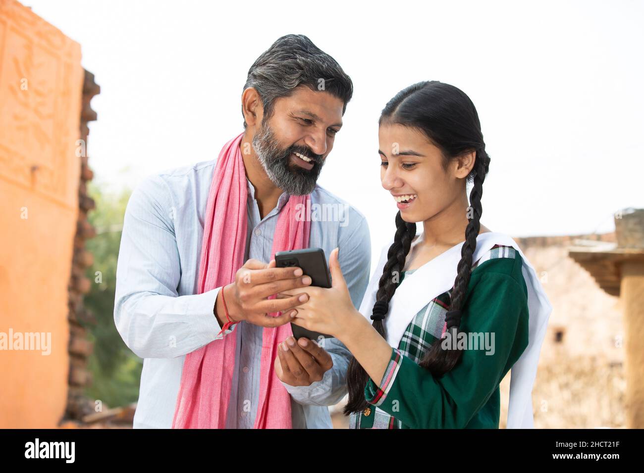 Happy Indian father with daughter wearing traditional cloths using smart  phone together, having fun, watching video, young girl teaching mature dad  to Stock Photo - Alamy