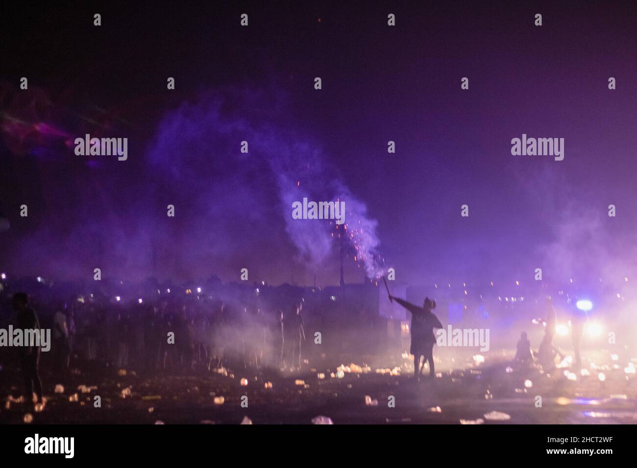 Palembang, South Sumatra, Indonesia. 1st Jan, 2022. A resident is holding fireworks ready to explode in the air. (Credit Image: © Muhammad Shahab/Pacific Press via ZUMA Press Wire) Credit: ZUMA Press, Inc./Alamy Live News Stock Photo