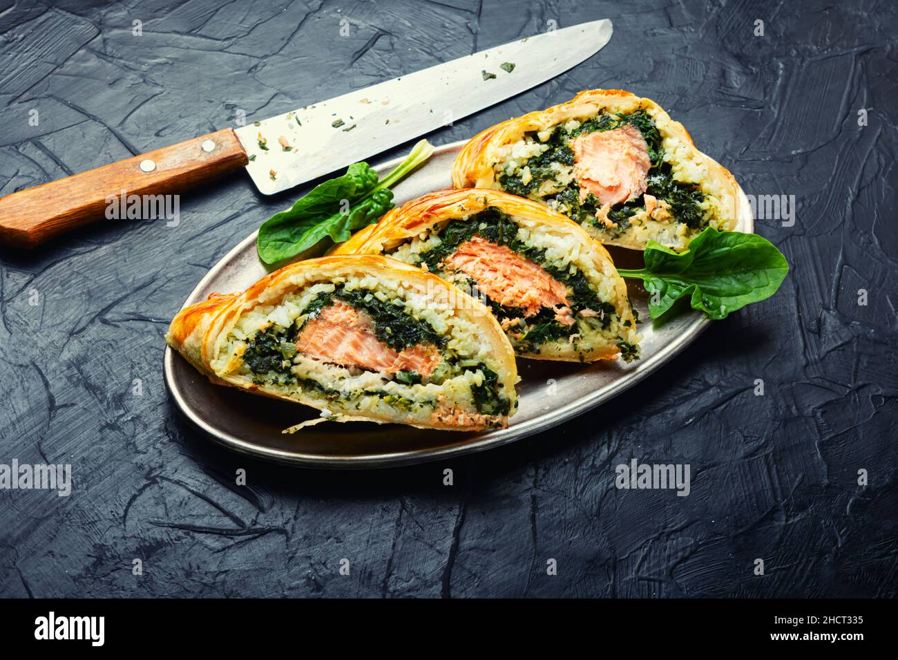 Tasty roll with salmon, rice and spinach. Fish pie. Fish wellington
