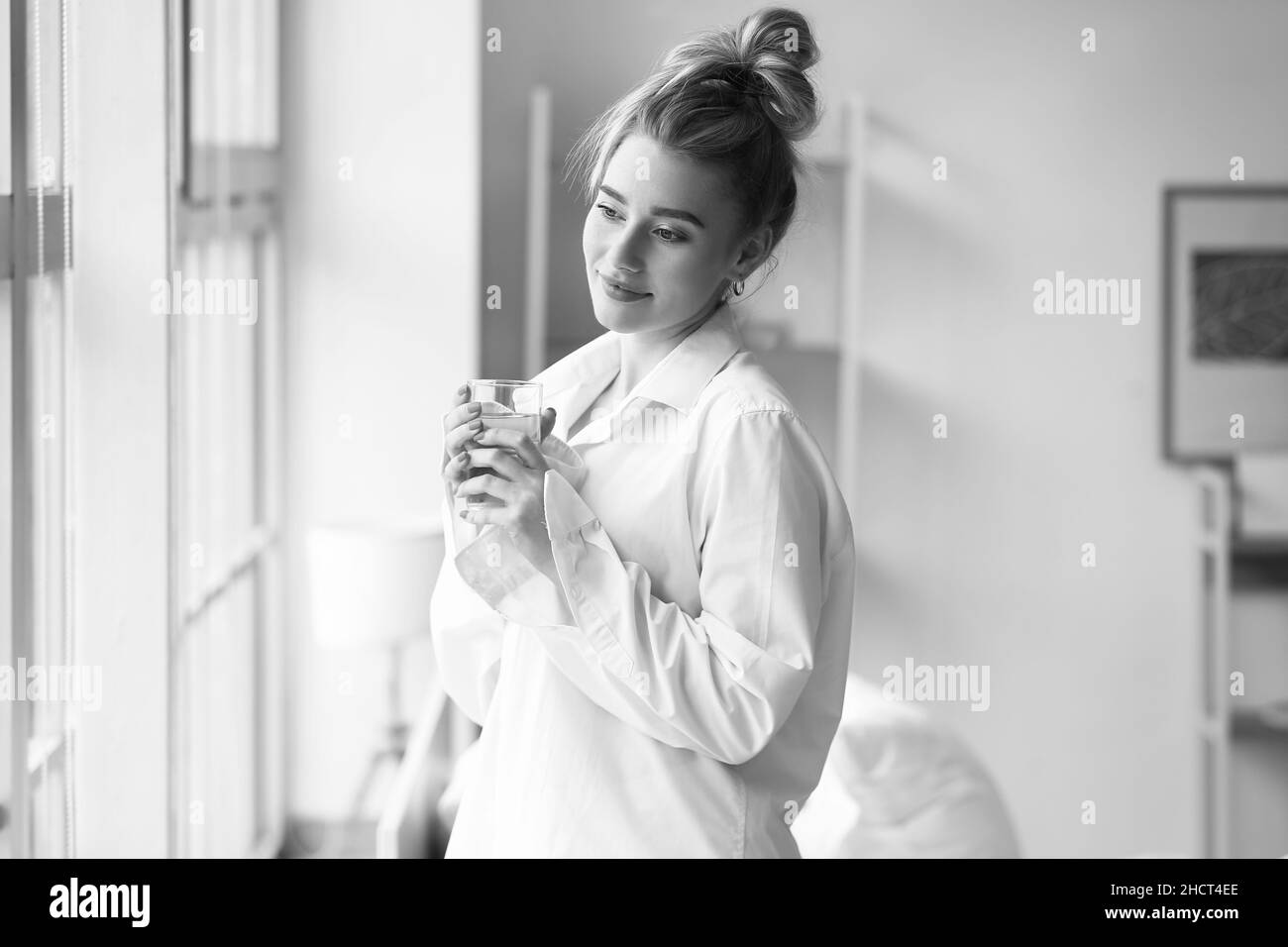 Morning of beautiful young woman drinking water at home Stock Photo