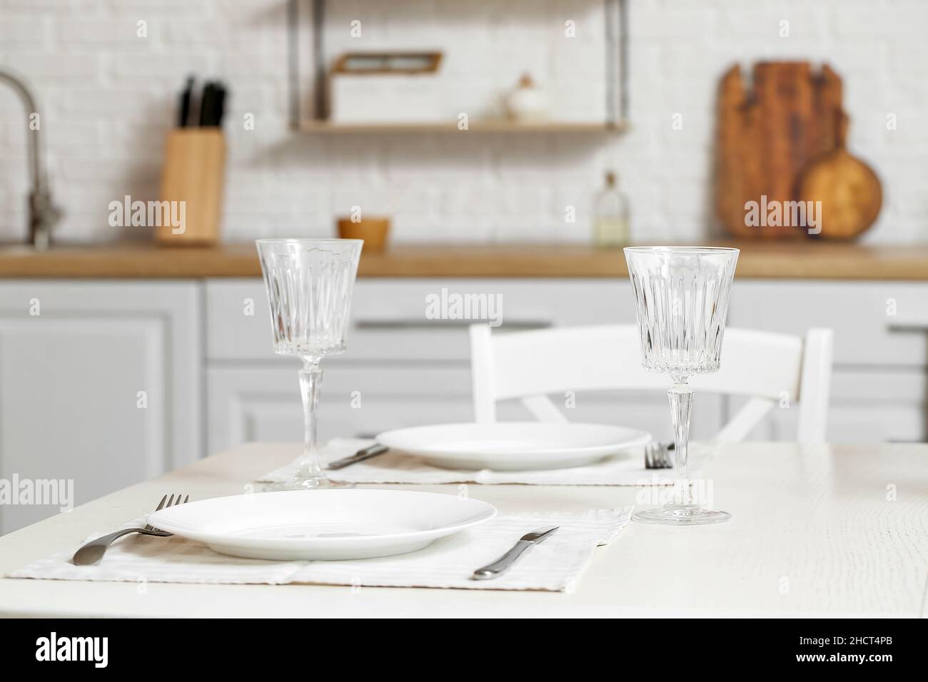 Dining table with empty glasses in kitchen Stock Photo - Alamy