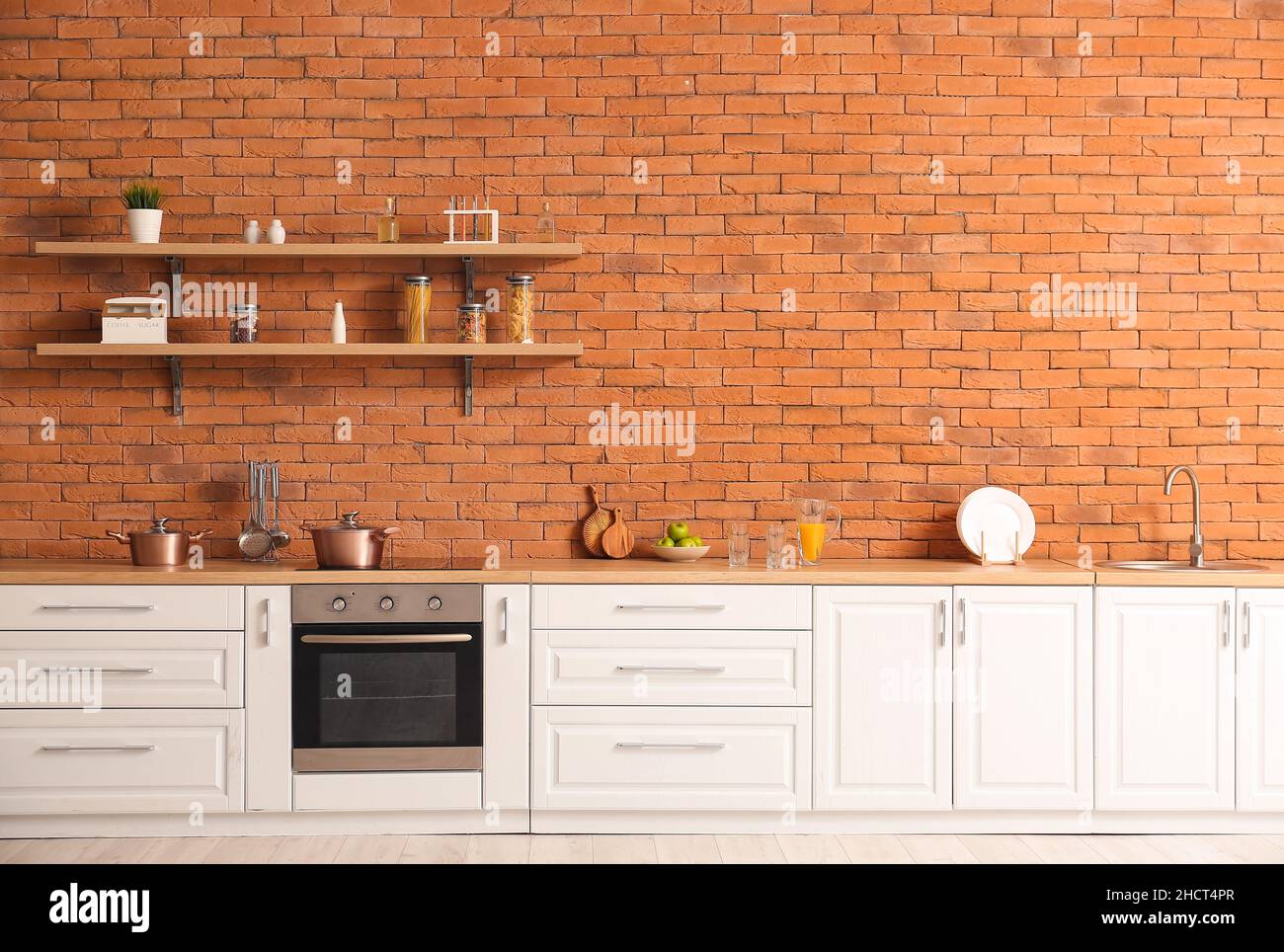 Interior of modern kitchen with white counters and brick wall Stock ...