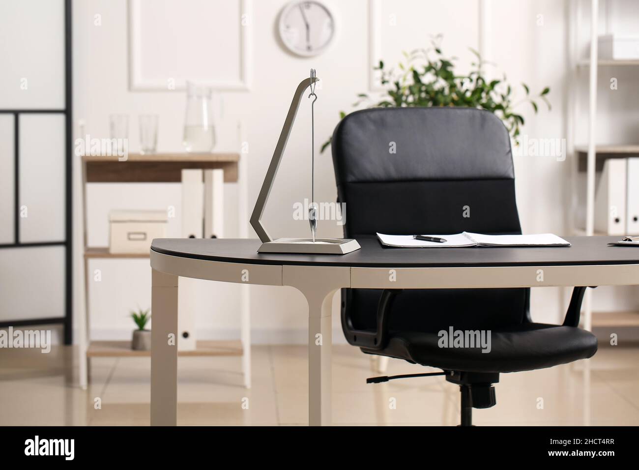 Modern pendulum on table in office Stock Photo Alamy