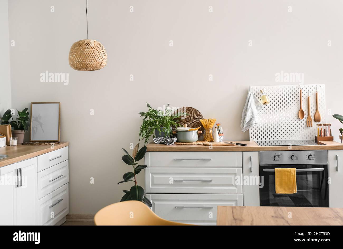 Interior of modern kitchen with white counters, oven and peg board ...