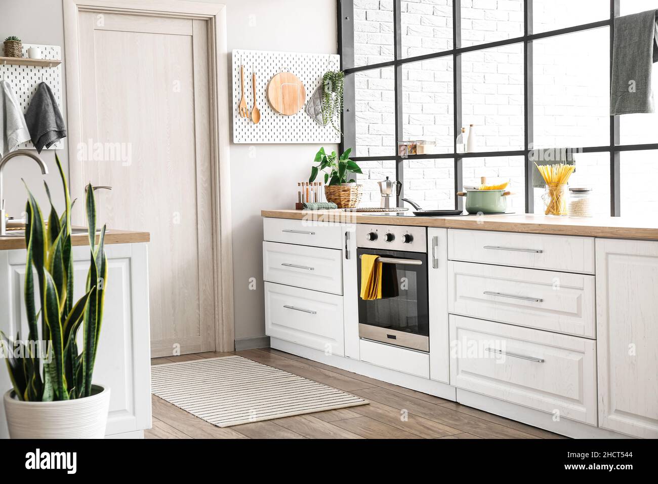Interior of modern kitchen with white counters, door and peg boards ...
