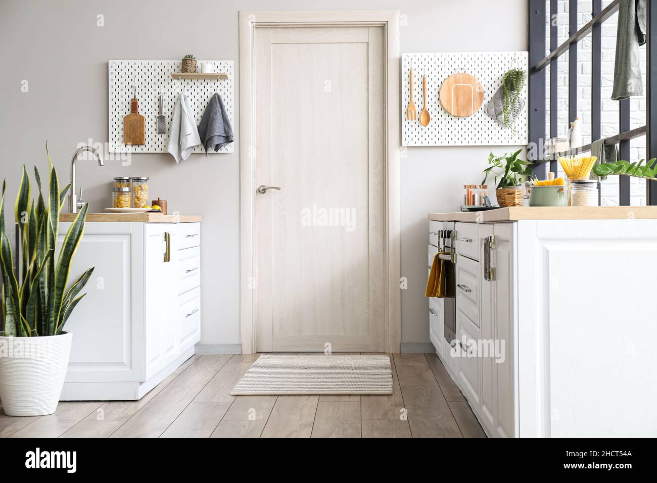 Interior of modern kitchen with white counters, door and peg boards ...