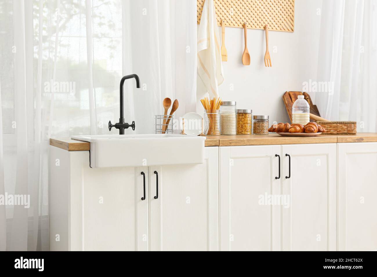 Interior of light kitchen with white counters, sink and food Stock ...