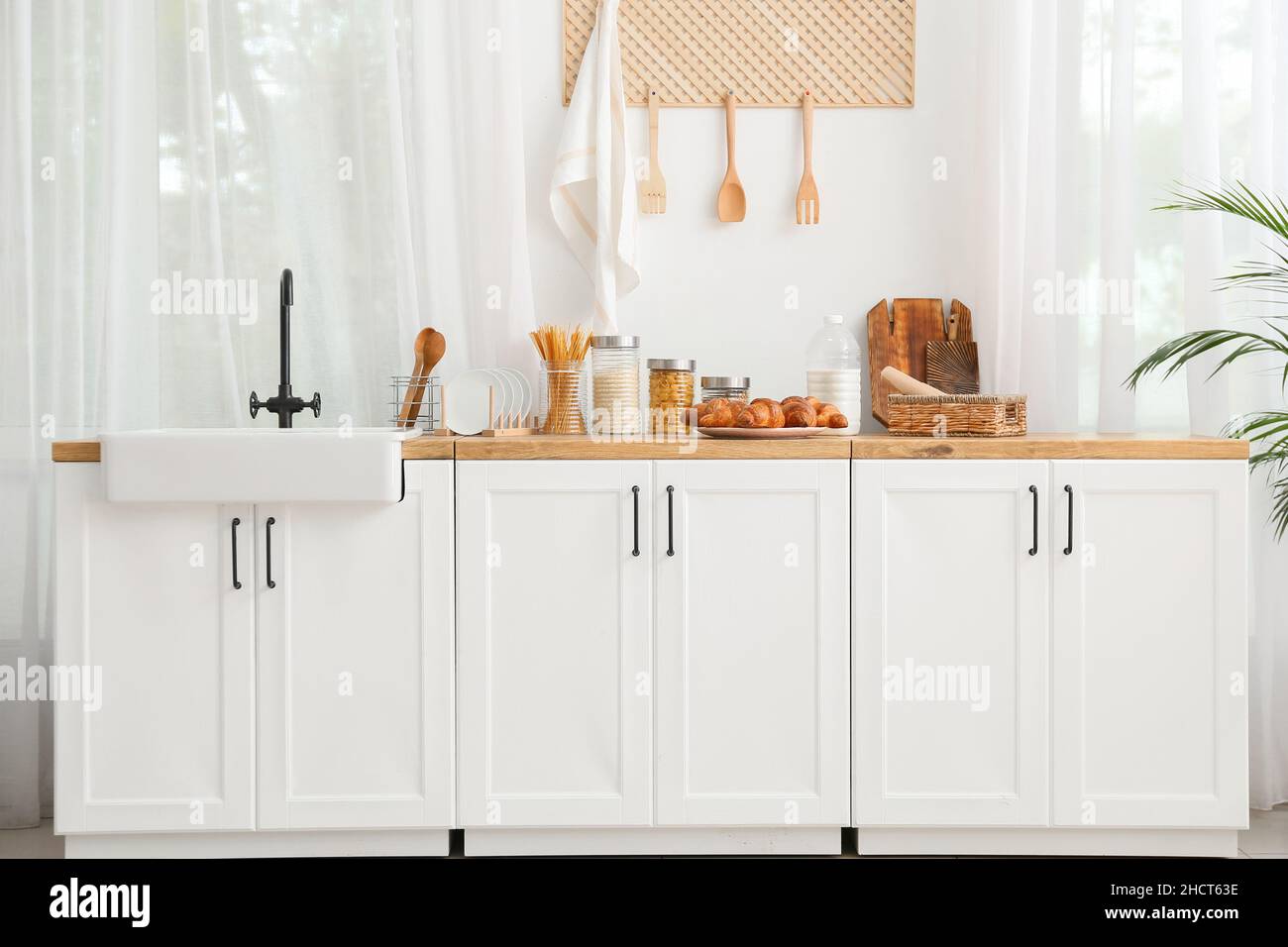 Interior of light kitchen with white counters, sink and food Stock ...
