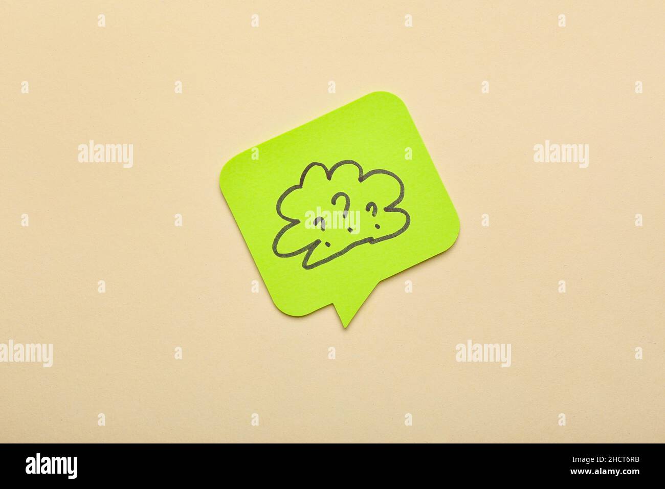 Sticky note with drawn cloud and question marks on beige background Stock Photo