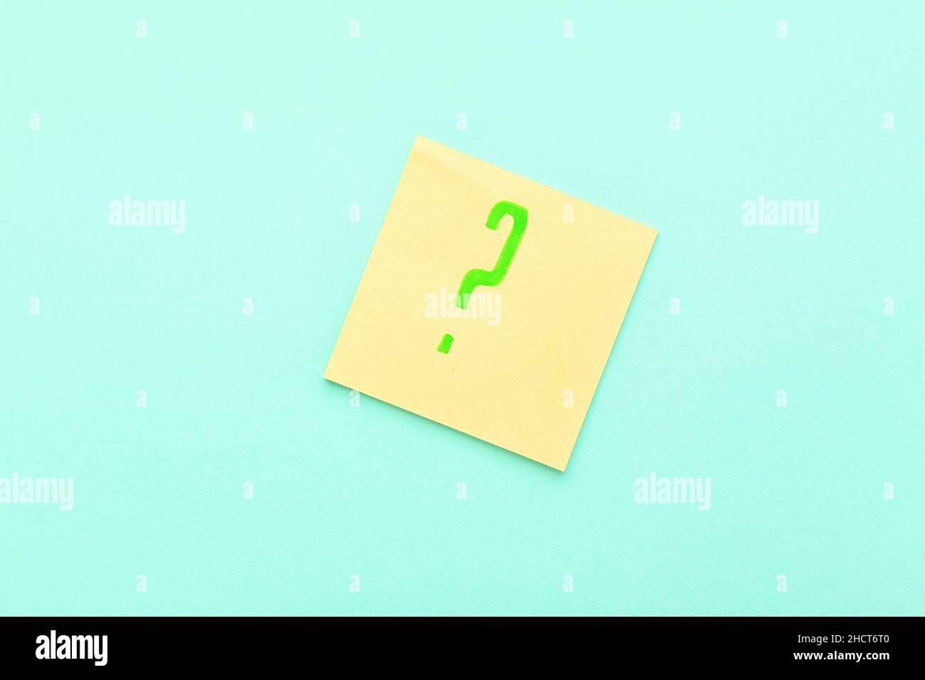Sticky note with green question mark on blue background Stock Photo - Alamy