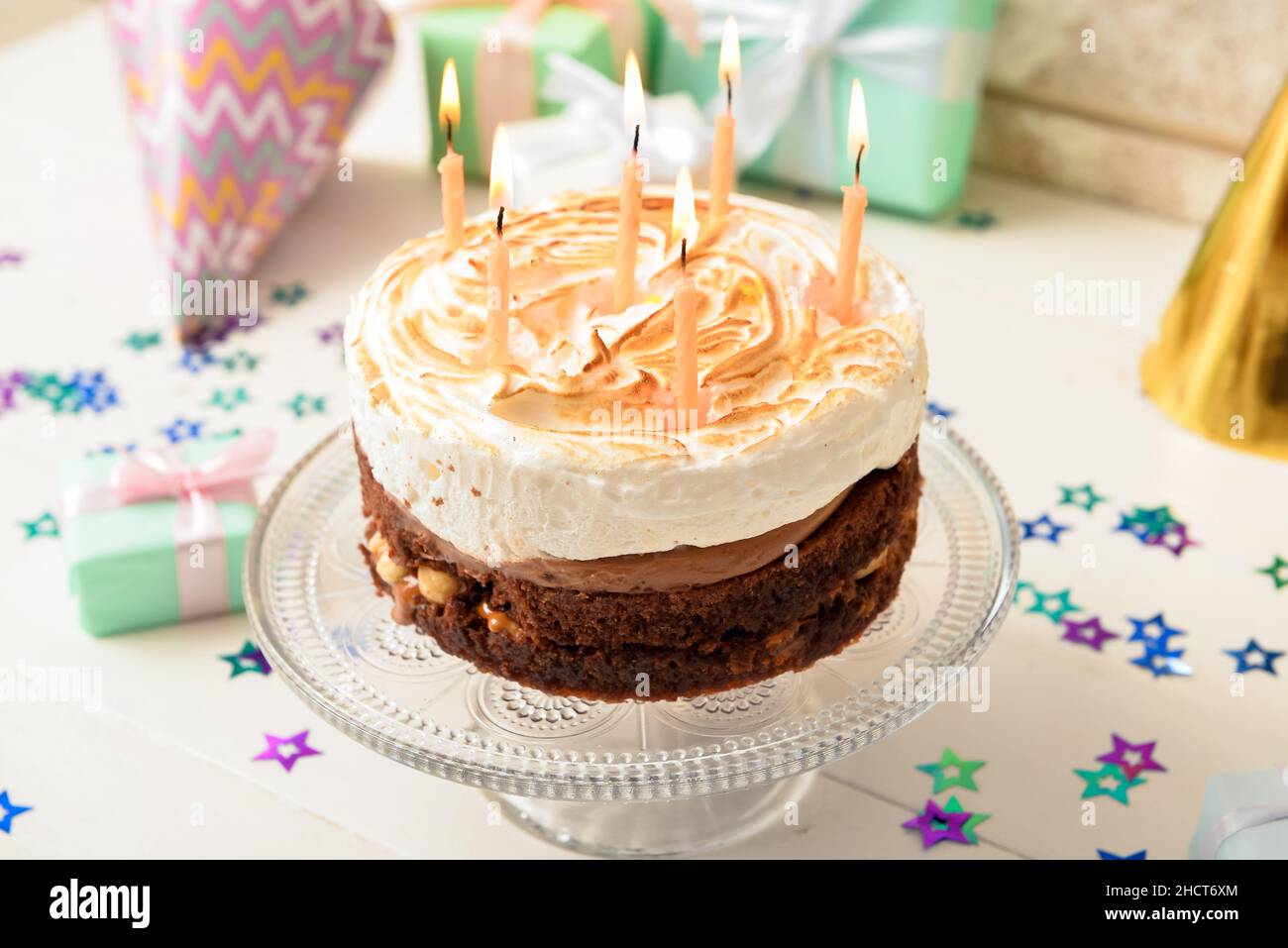 Stand with tasty birthday cake and confetti on light background Stock ...