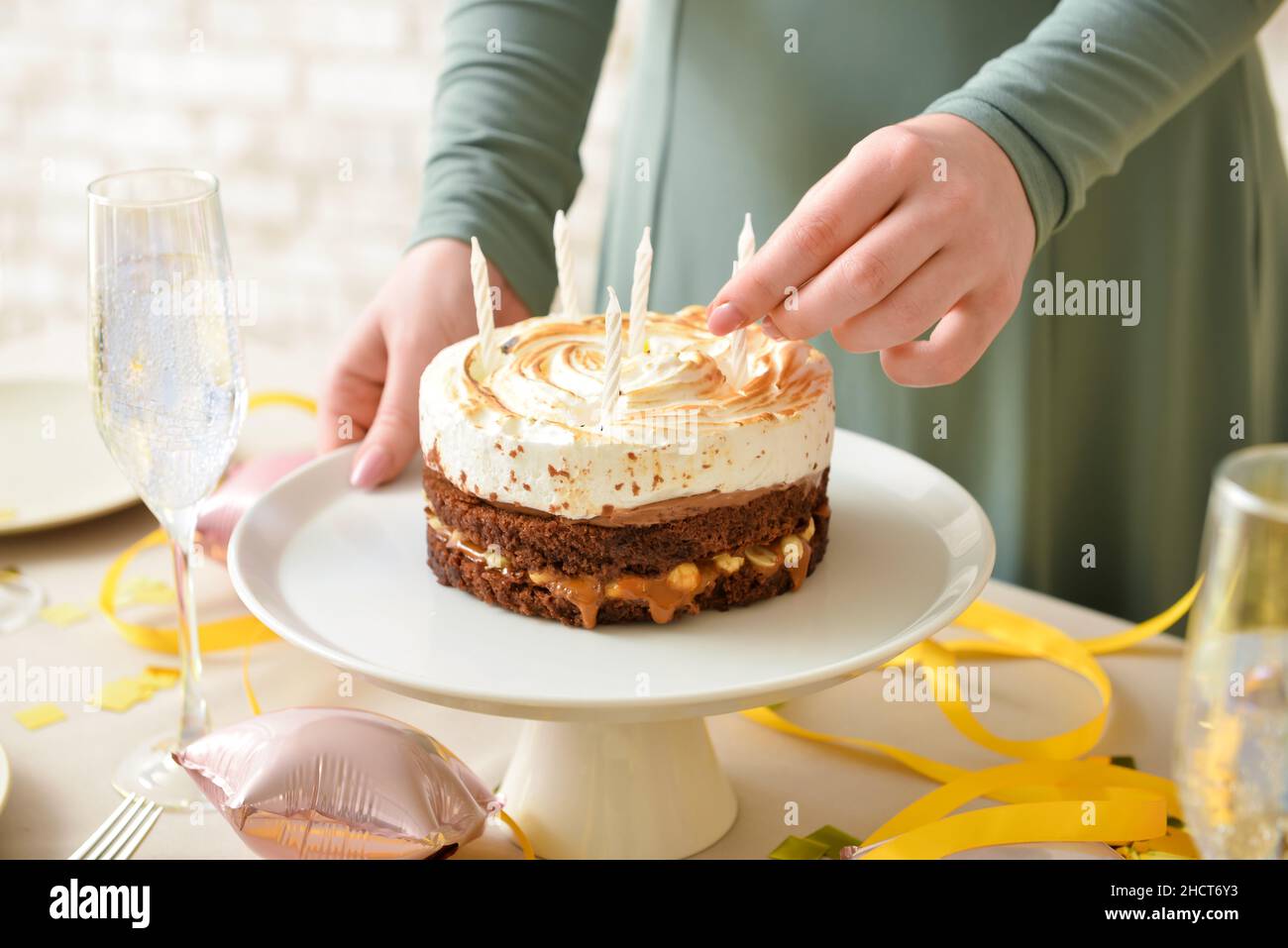 Woman decorating tasty birthday cake with candles at table Stock Photo ...