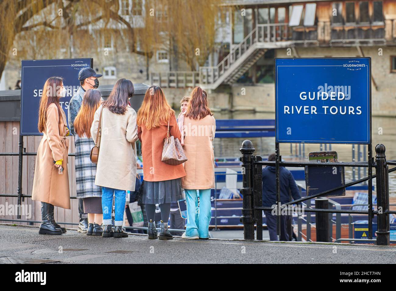 Group of chinese tourists enquire about a guided punt tour on the river Cam, England. Stock Photo