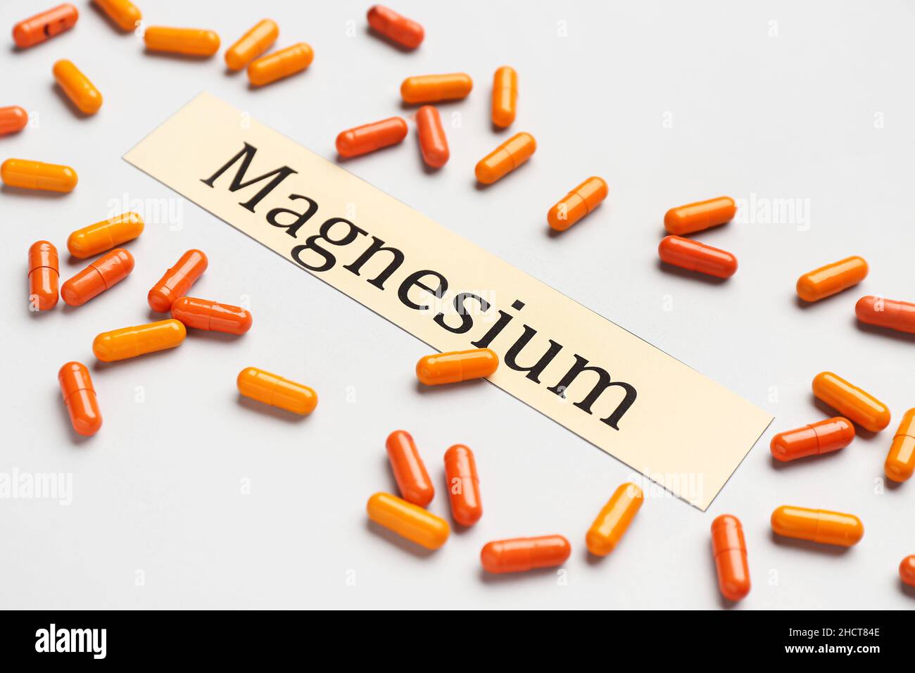 Colorful capsules and word MAGNESIUM on light background Stock Photo