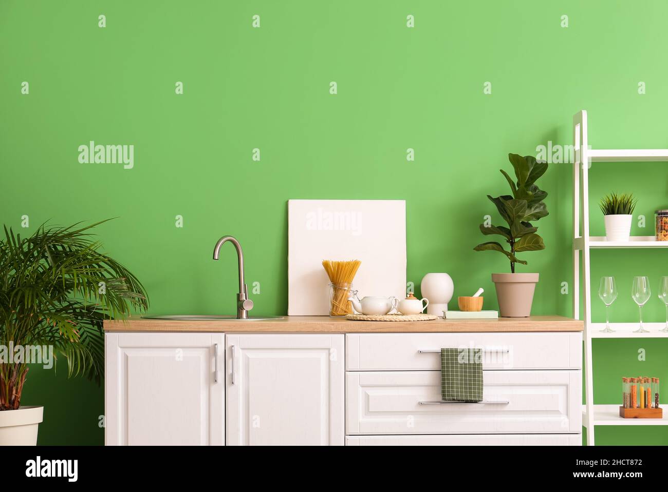 Interior of stylish kitchen with white counters, shelving unit and ...