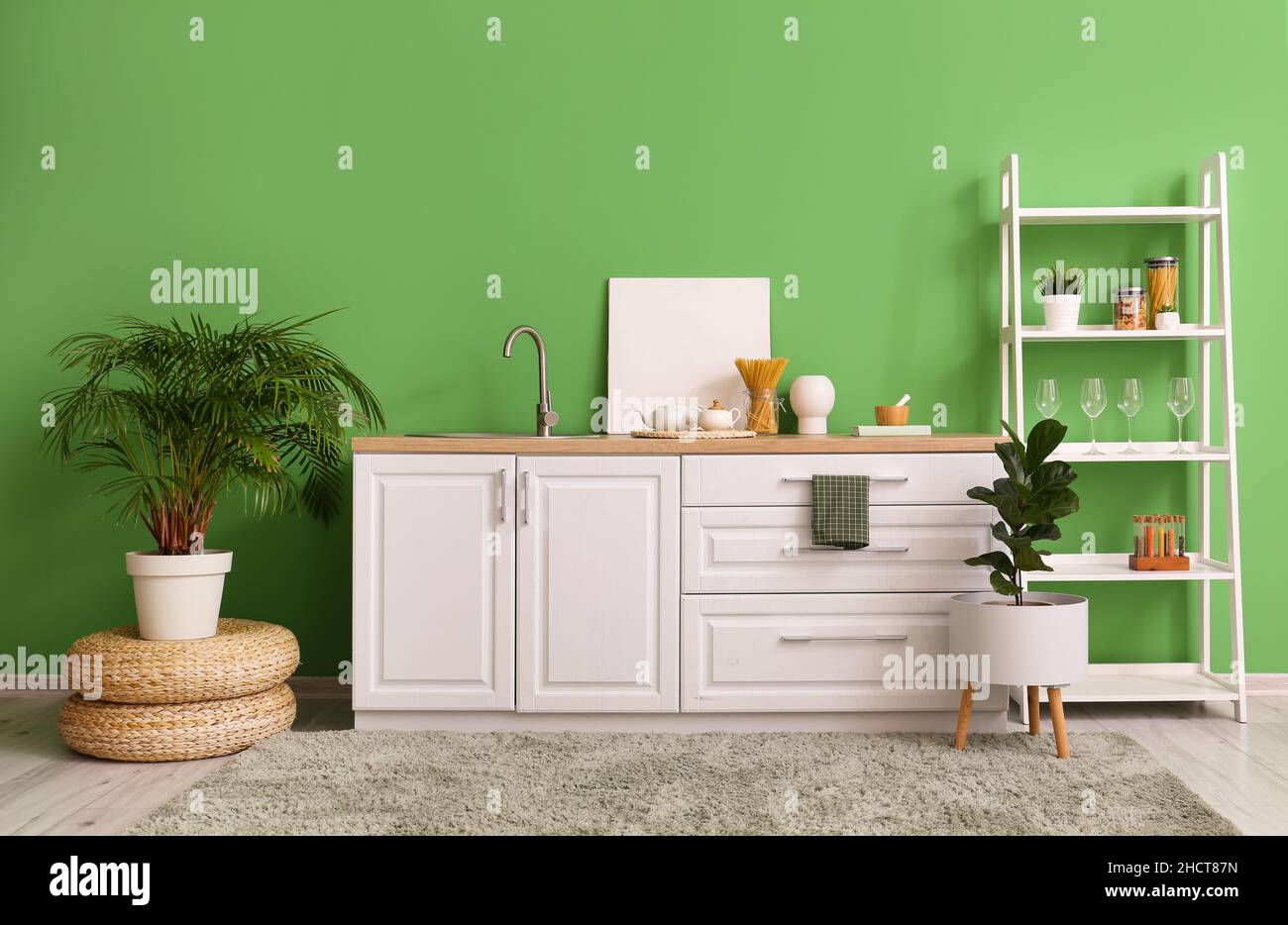 Interior of stylish kitchen with white counters, shelving unit and ...