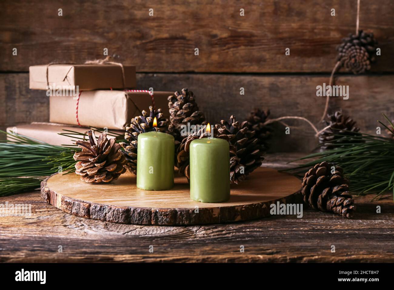 Board with burning candles and pine cones on wooden table Stock Photo ...