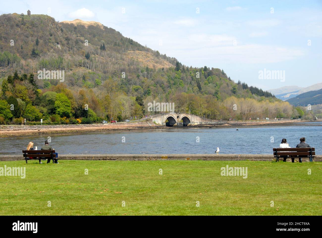 Groups of people sitting looking out over Lock Fyne, Inveraray, Argyll & Bute, Scotland Stock Photo