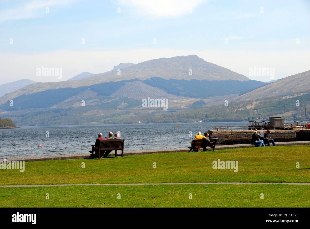 Groups of people sitting looking out over Lock Fyne, Inveraray, Argyll & Bute, Scotland Stock Photo