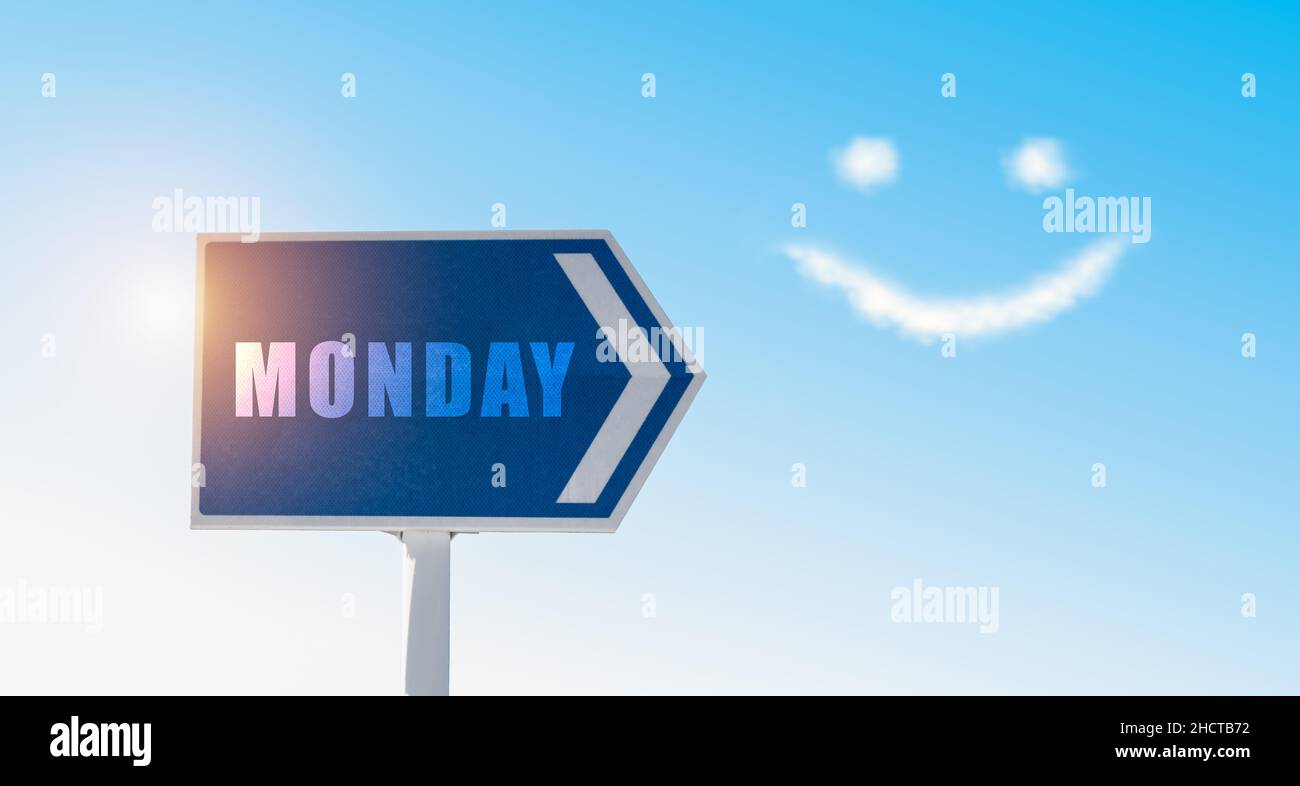 Monday sign against blue sky with happy clouds face. Stock Photo