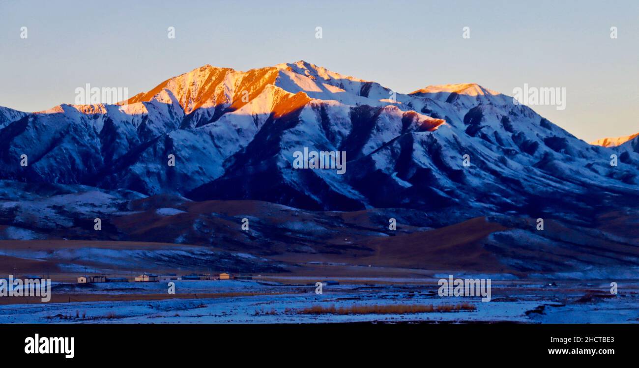 ZHANGYE, CHINA - JANUARY 1, 2022 - The first rays of 2022 sunshine spread over baars Snow Mountain in Zhangye City, Gansu Province, China, On January Stock Photo