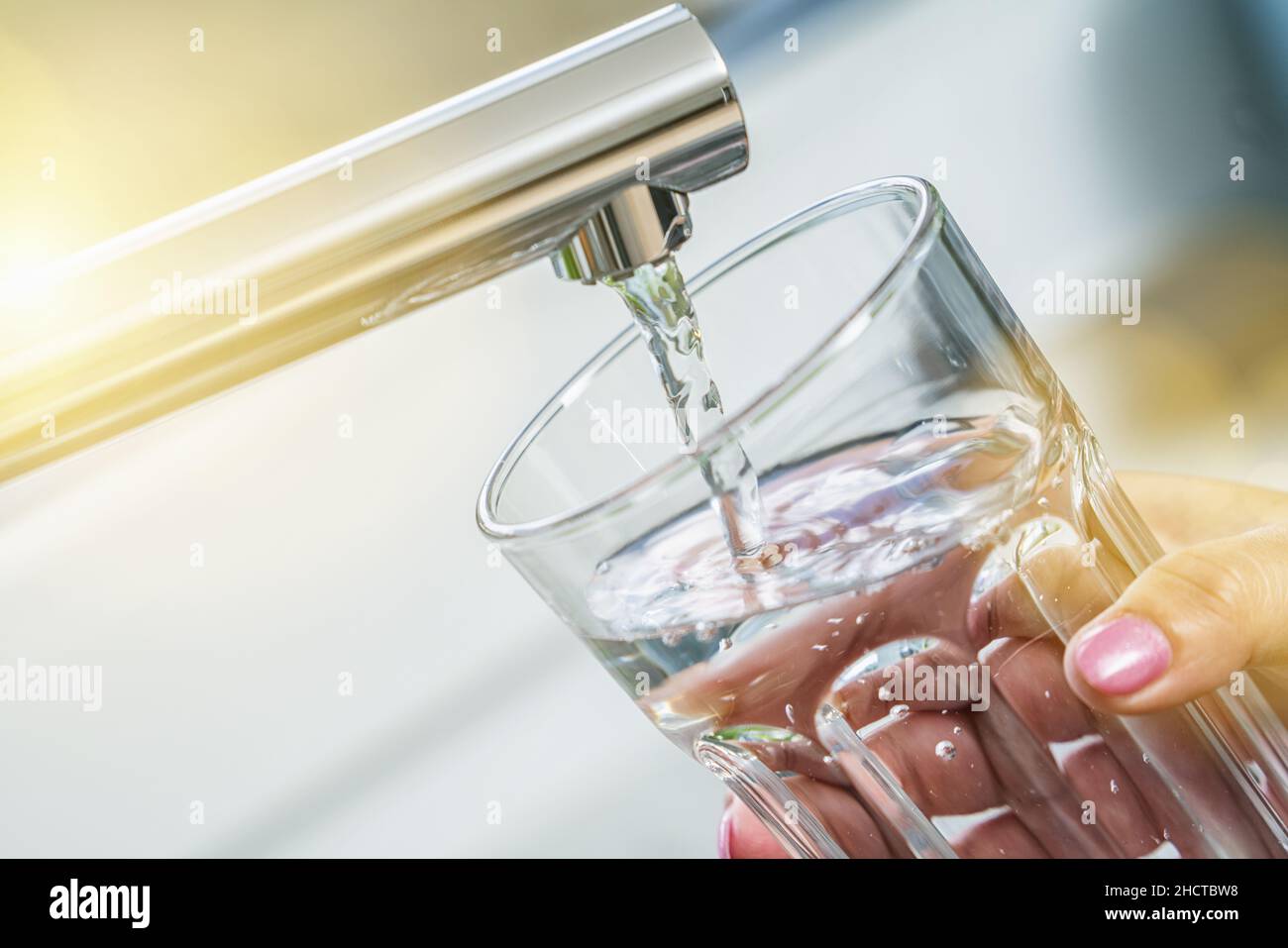filling glass with drinkable water Stock Photo