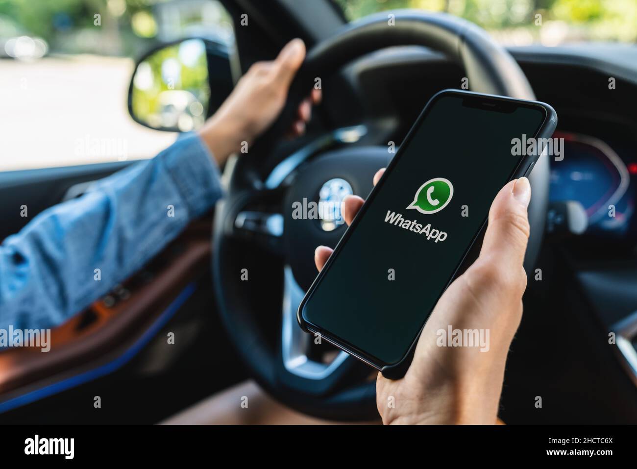 Woman hand holding iphone Xs with logo of instagram application in a car. Instagram is largest and most popular photograph social networking. Stock Photo