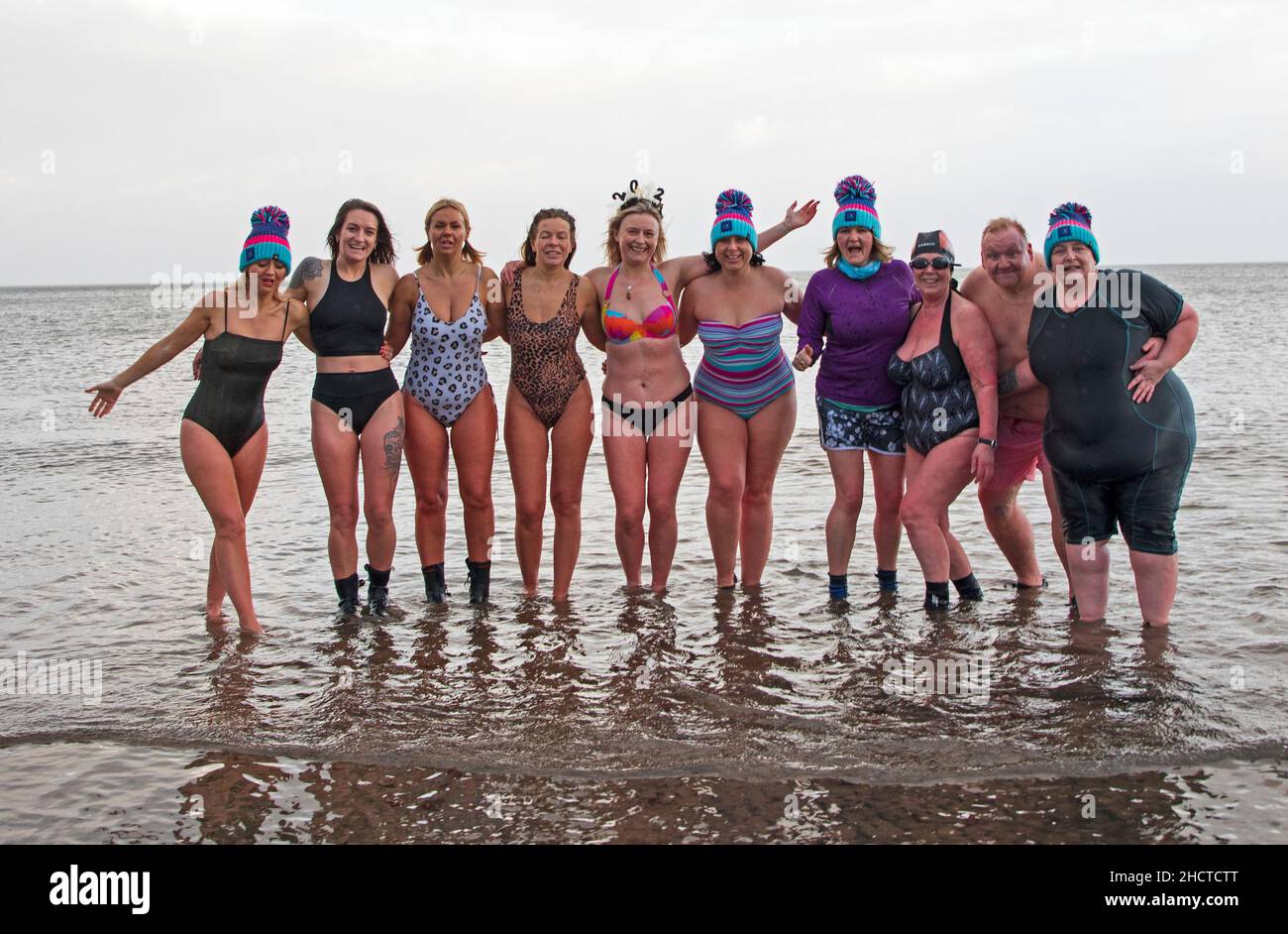 Portobello, Edinburgh, Scotland, UK. 1st January 2022. at Porty as Queensferry Loony Dook cancelled. Temperature at 14 degrees. Warm Porty Dook in the Firth of Forth for New Years Day. Pictured: Tracy Watt fundraising manager in purple and group doing a sponsored dip for the local baby loss charity  'Held in our Hearts'. Campaign Splash into 2022 brings local people together. Credit: Arch White/Alamy Live News. Stock Photo