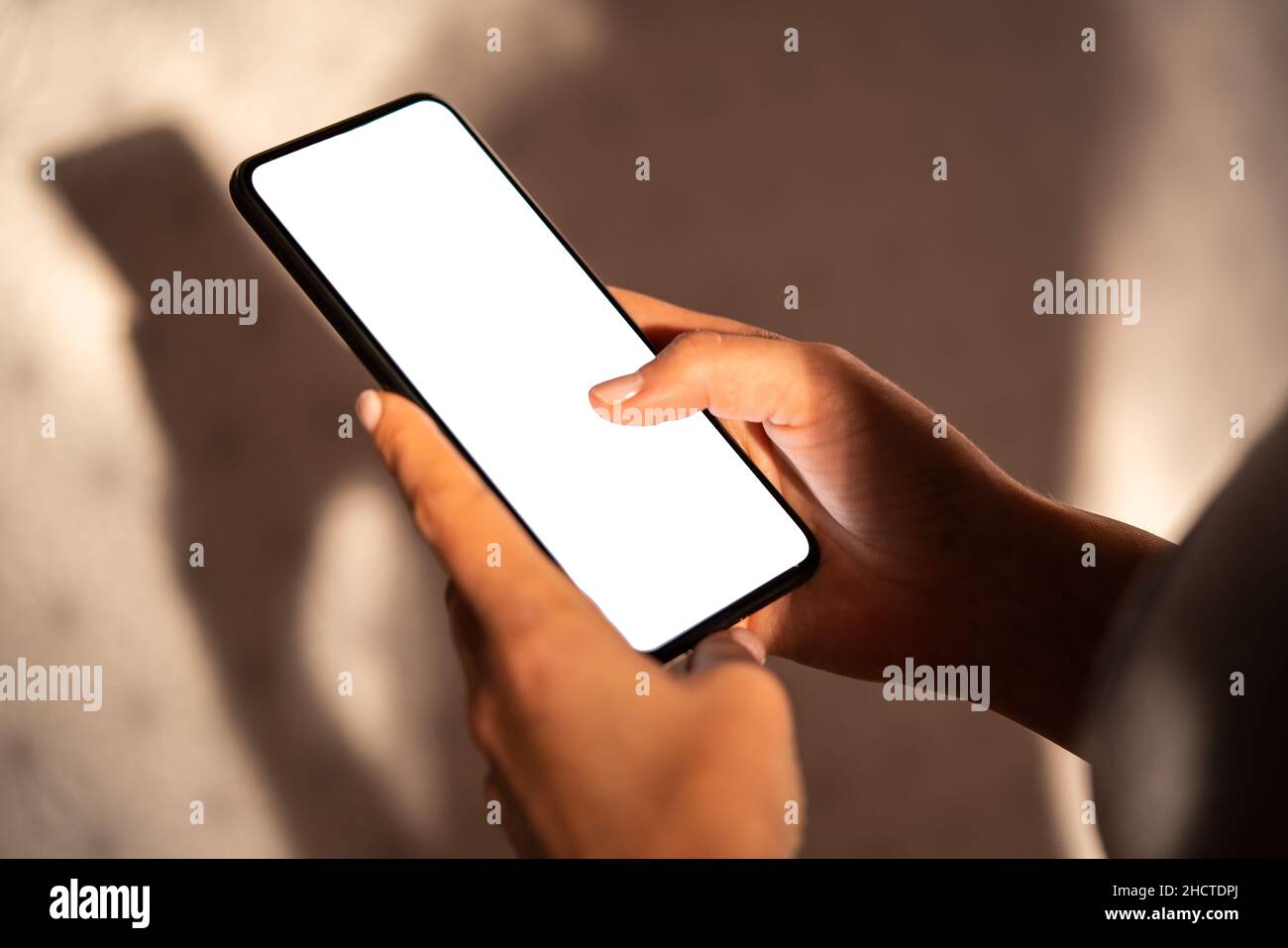 hands holding mobile phone with blank desktop screen at Home, Mockup image Stock Photo