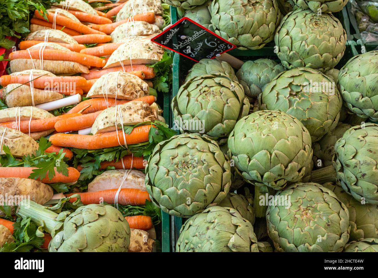 Soup greens and artichokes for sale at a market Stock Photo