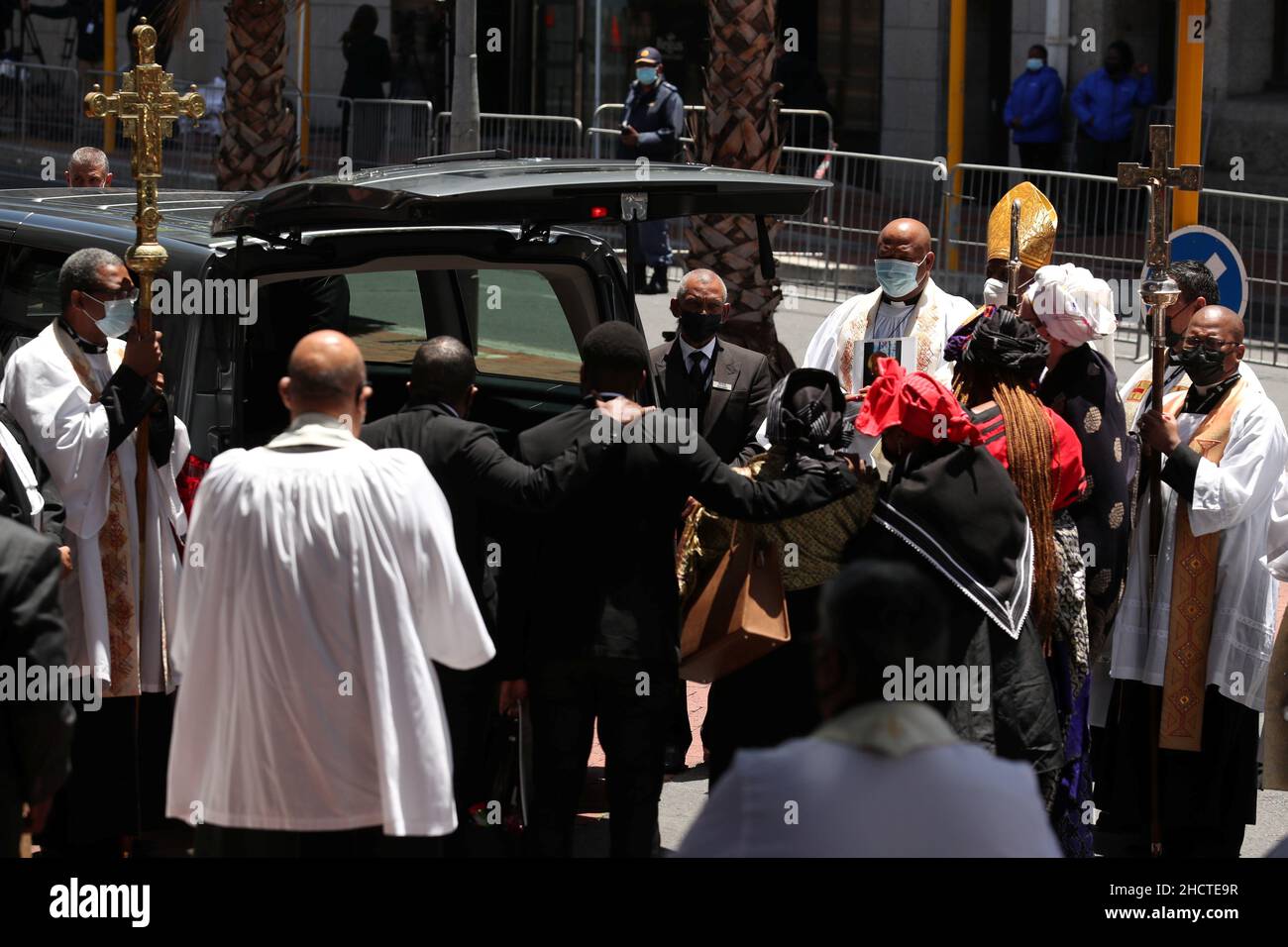 People and members of the clergy gather near the hearse carrying the casket holding the body of Archbishop Desmond Tutu after his funeral service at St George's Cathedral in Cape Town, South Africa, January 1, 2022. REUTERS/Mike Hutchings Stock Photo