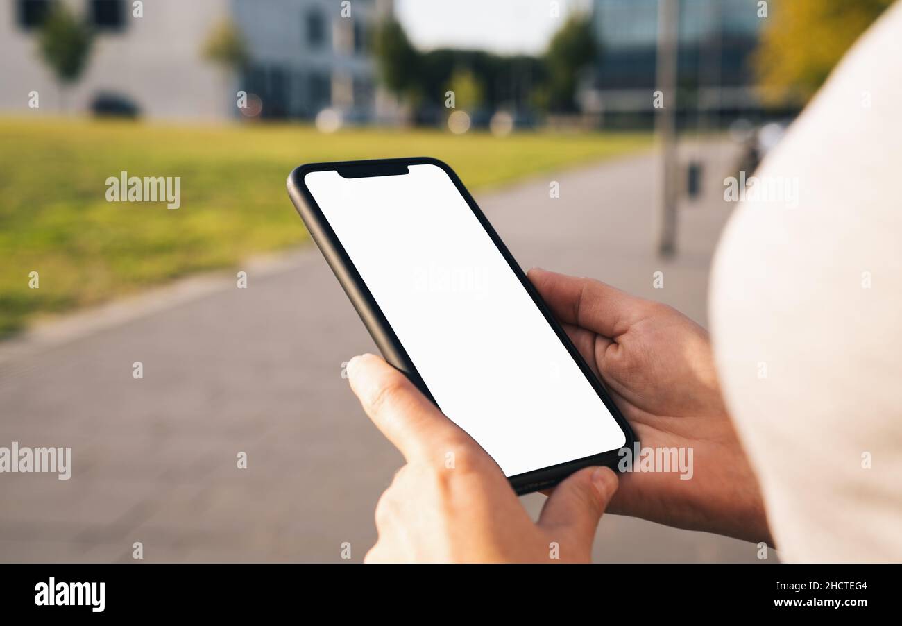 Mockup image of hands holding black mobile phone with blank desktop