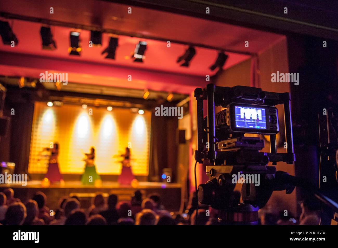 Digital video camera recording dance show. Warm ambience Stock Photo