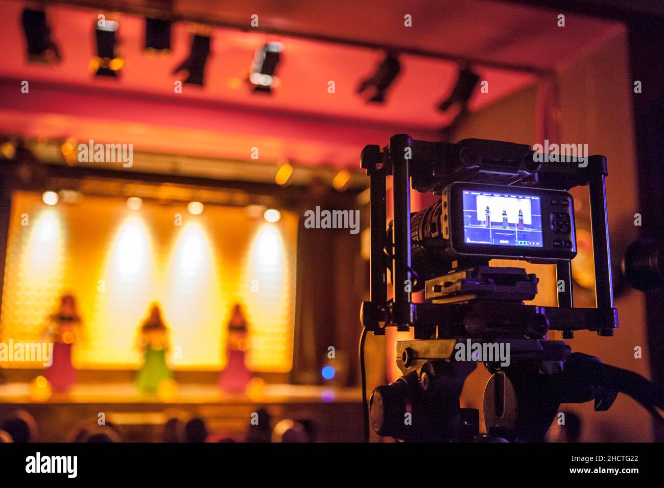 Digital video camera recording dance show. Warm ambience Stock Photo