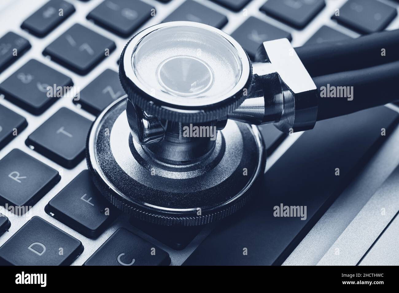 Silver stethoscope lying down on an laptop Stock Photo