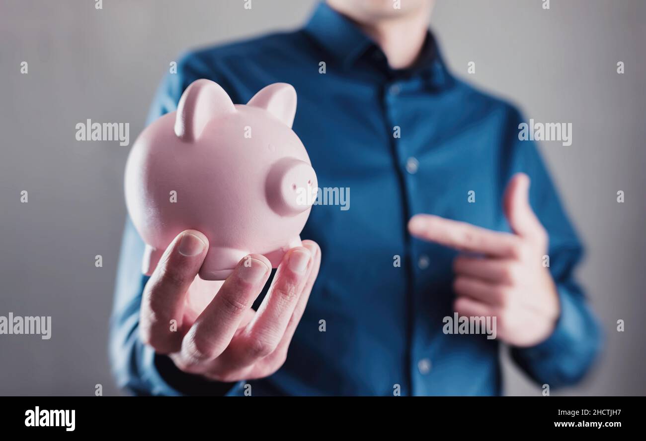 Young man holding a piggy bank Stock Photo - Alamy