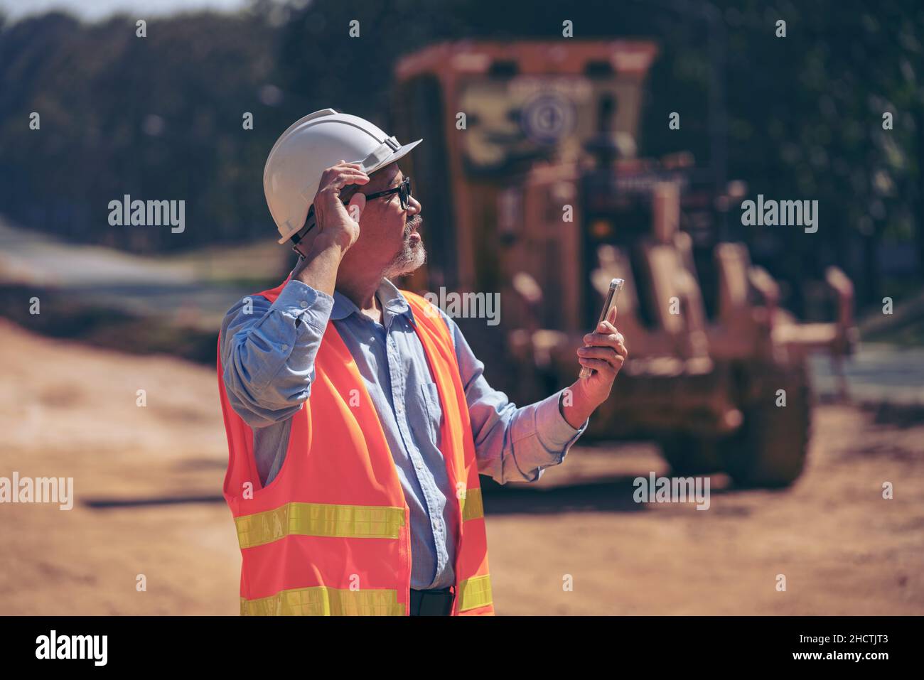 Surveyor builder Engineer technician  Business Team discuss plan at new construction site. Road construction machinery on the construction of highway. Stock Photo