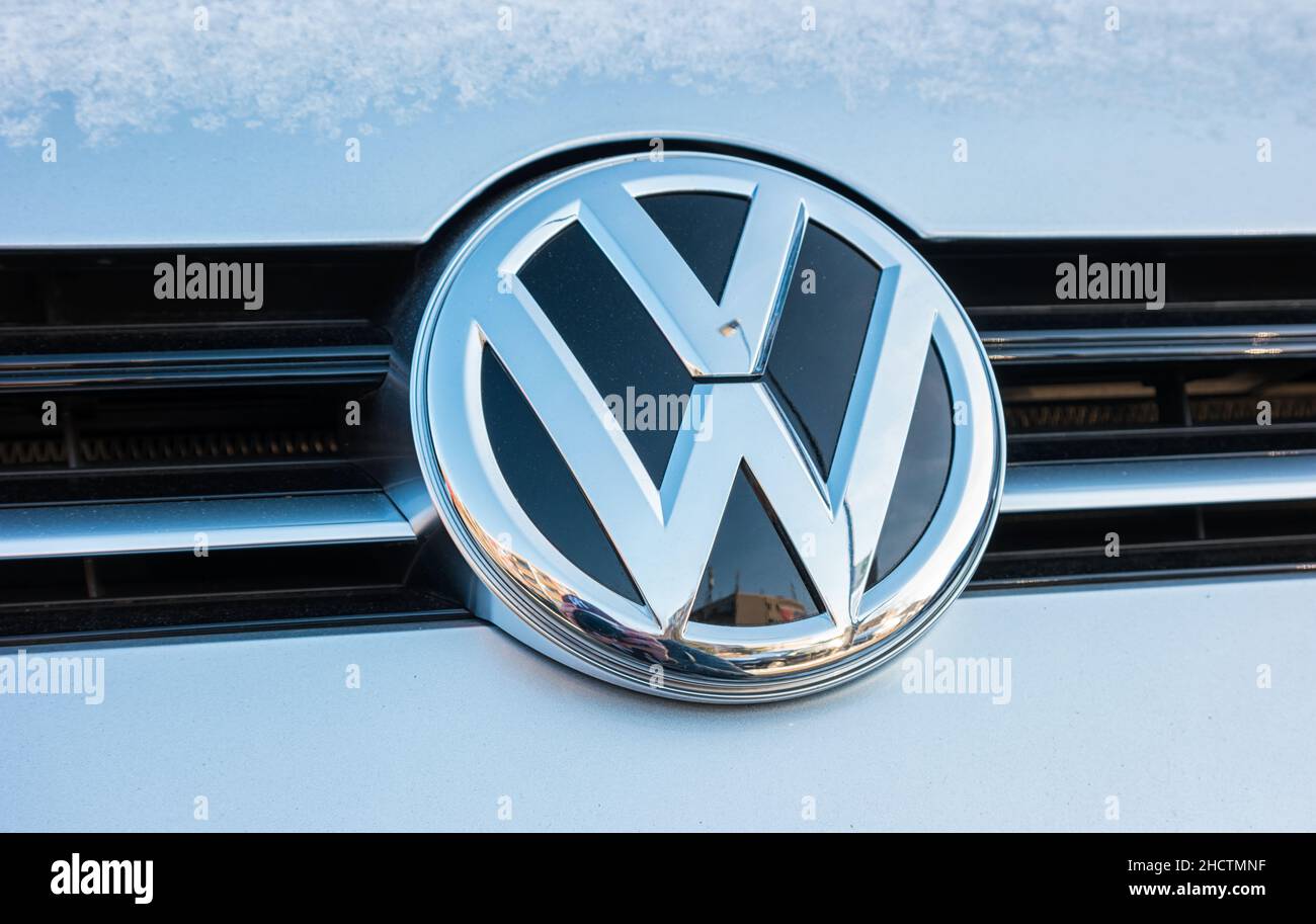 Sign of a Volkswagen logo on a car at winter. Volkswagen is a company of the Volkswagen Group. Stock Photo