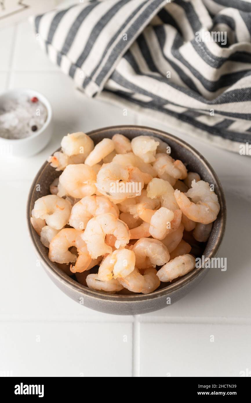 Thawed peeled shrimp, seafood, delicacy. on a white background, in a ...