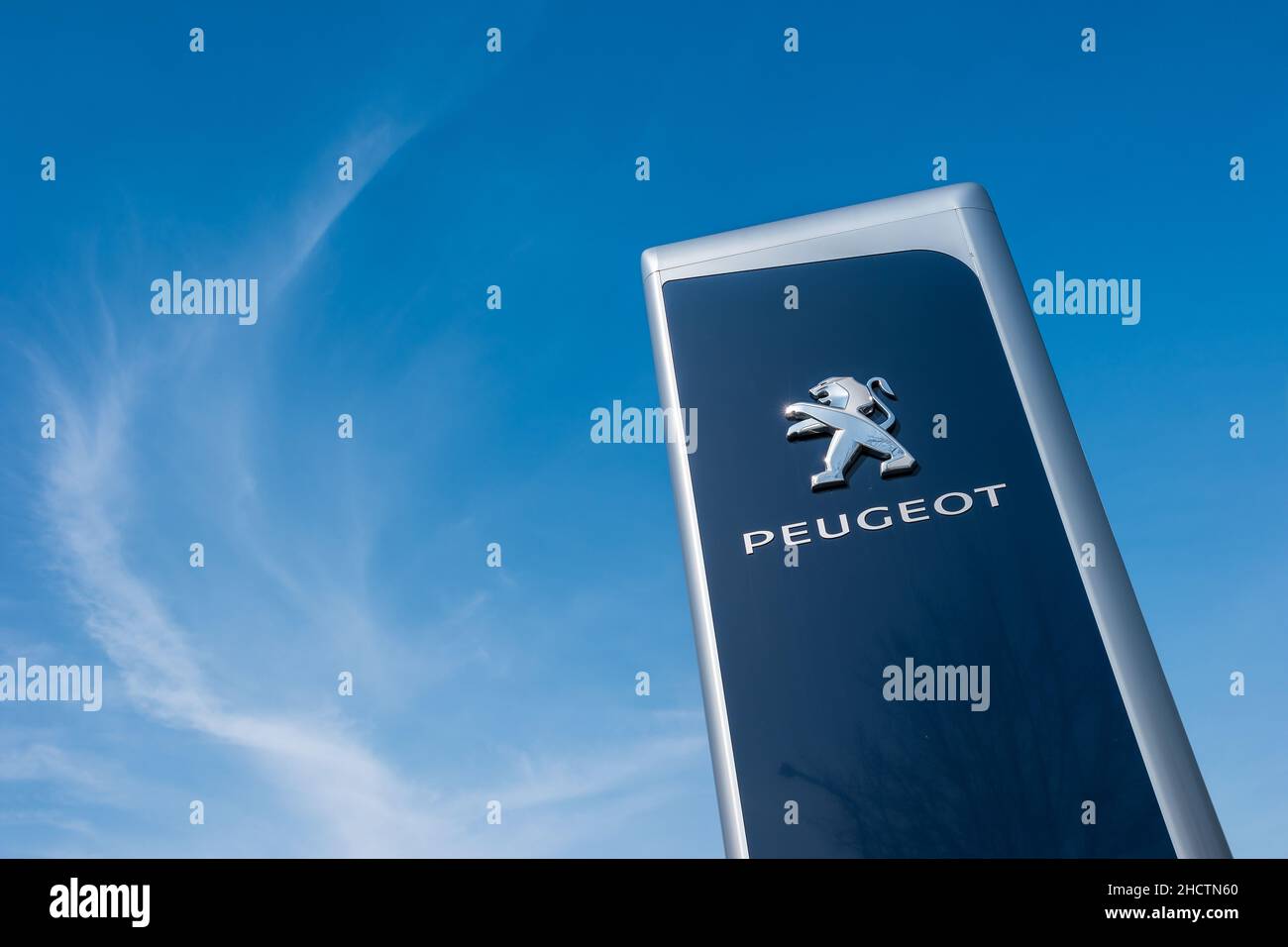 Peugeot dealership sign against blue sky. Peugeot is a French automobile manufacturer and part of Groupe PSA. Stock Photo