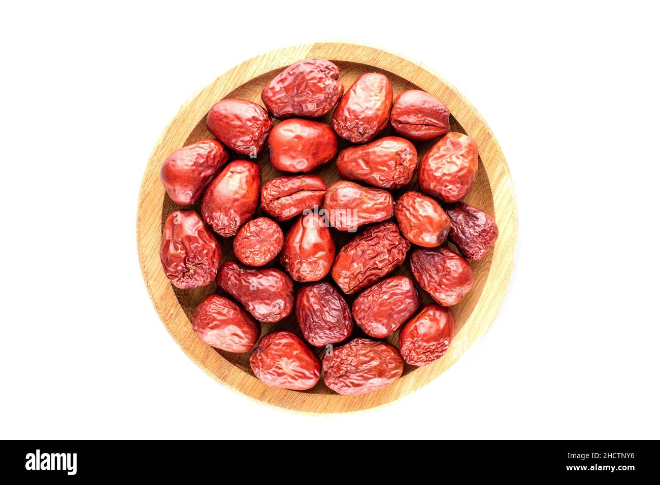 Several sweet dried ziziphus berries on a wooden tray , close-up, top view. Stock Photo