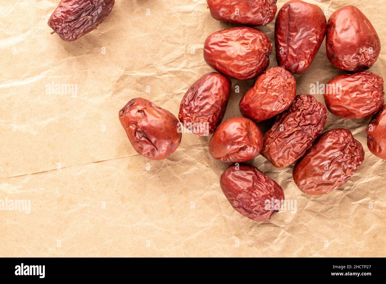 Several sweet dried ziziphus berries on craft paper, close-up, top view. Stock Photo
