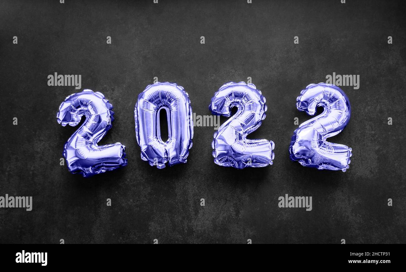 Inflatable numbers New Year 2022 Very Peri color on black background. Copy space. Holiday trends and party concept Stock Photo